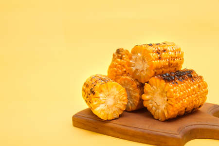 grilled corn on a yellow background, copy space