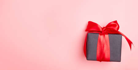 Black friday sale flat lay with gift box and ribbon, copy space, christmas and holidays concept on pink backgroundの写真素材