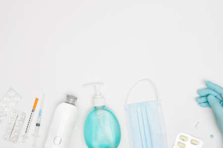 Medical face mask with alcohol disinfectant gel bottle for washing hands isolated on white background covid-19 coronavirus prevention concept flat layの写真素材