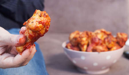 man on the couch with a plate of Buffalo Chicken Wings, copy spaceの写真素材