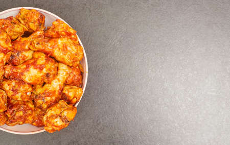 Buffalo chicken wings in a plate on a black table background, copy spaceの写真素材