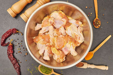marinated chicken wings in a metal bowl on the tableの写真素材
