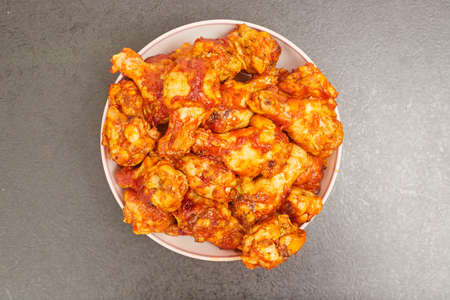 Buffalo chicken wings in a plate on a black table background, copy spaceの写真素材