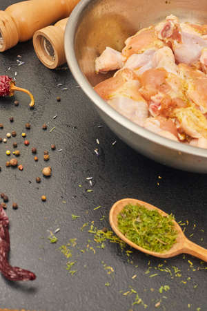 marinated chicken wings in a metal bowl on the tableの写真素材
