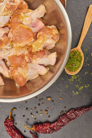 marinated chicken wings in a metal bowl on the tableの写真素材