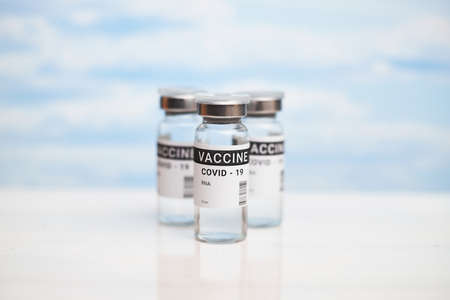 Three cans of coronavirus vaccine. against the background of the blue sky with olaks. copy space, bannerの写真素材