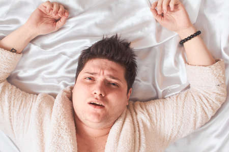 Caucasian Man Lying Bed White High Key, Close-Upの写真素材