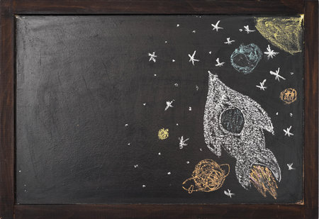 a rocket with planets is drawn on a chalk boardの写真素材