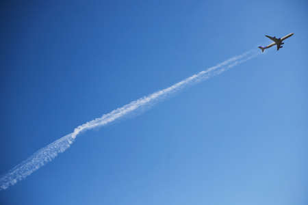 the plane in the clear sky takes off leaving the lineの写真素材