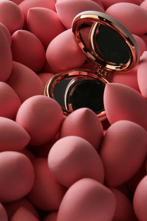 beauty background a bunch of pink gentle makeup sponges and a mirror vertical orientation dark keyの写真素材