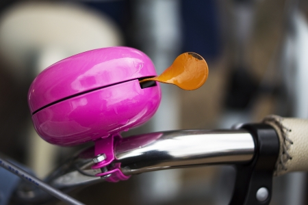 purple bicycle bell with orange earの写真素材