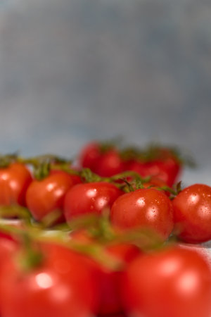 Appetizing and healthy fresh tomatoes and spinach on a handmade background, drizzled with water for a vegan dietの写真素材