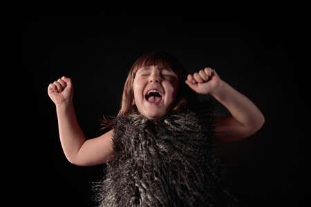elegant four year old Caucasian girl dressed in feather vest with adorable and endearing expression...