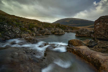 double waterfall in river with silky water. dry autumn grass- Fairy Pools - Skye Island - Scotland -...