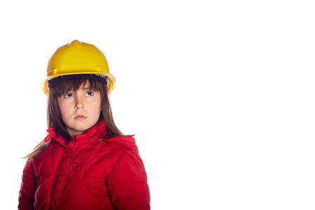 4 year old girl with surprise gesture looking towards a blank space with a yellow construction helmet looking at camera with copy space. construction concept. construction store advertisingの写真素材