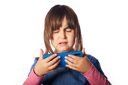 young Caucasian girl with a phone in her hands and looking at it with each disgust and reproach....