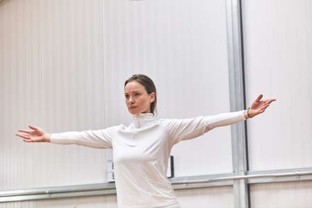beautiful Latina woman trainer teaching pilates in an indoor gym with copy space