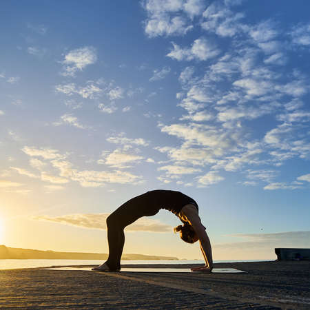 Young woman practicing yoga in a urban background