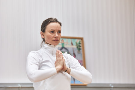blonde Caucasian woman meditating on hands together in yoga asana posture