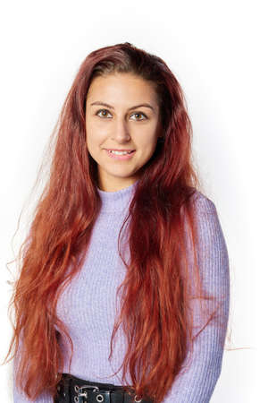 portrait of young Caucasian student woman with red hair smiling and looking at the camera.