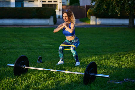 personal fitness trainer performing stretching exercises and lifting weights in outdoor environments.の写真素材