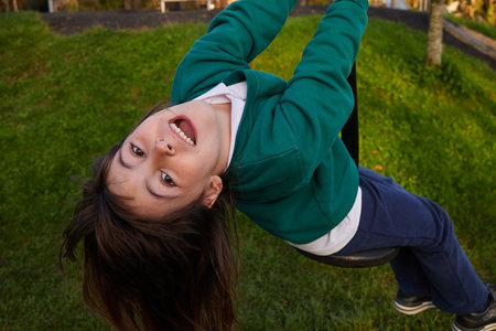 overhead shot of a five-year-old girl in a school uniform hanging from a rope.の写真素材