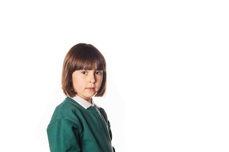portrait of a 5-year-old girl in a school uniform on a white background with a neutral expression and looking at the camera. Who returns to junior school.の写真素材