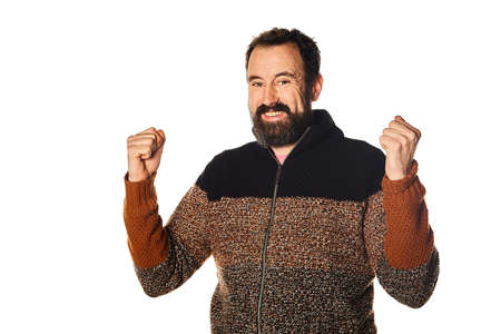 Happy and smiling Caucasian bearded man, making the victory sign with his hands. goals achieved.