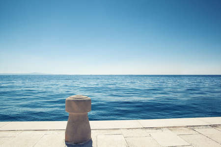 stone bollard on boat dock and seaの写真素材