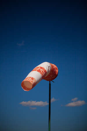 wind red and white sock against a blue skyの写真素材