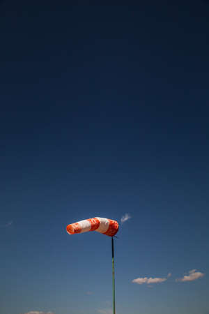 wind red and white old sock against a blue skyの写真素材