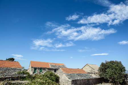 old stone rustic house and blue summer skyの写真素材