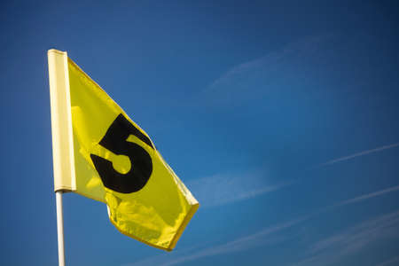 yellow golf flag in hole on greenの写真素材