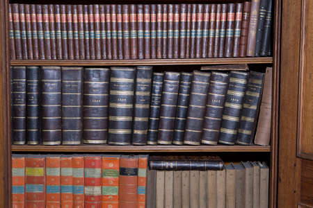 Old books in a wooden row libraryの写真素材