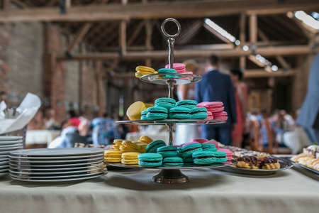 pink, yellow and blue macarons on tableの写真素材