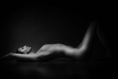 sexy naked attractive girl lying on woodden floorの写真素材
