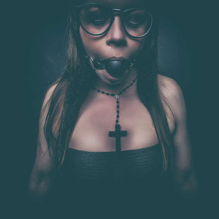 fetish dark portrait glamour girl in hat and bra with gagの写真素材