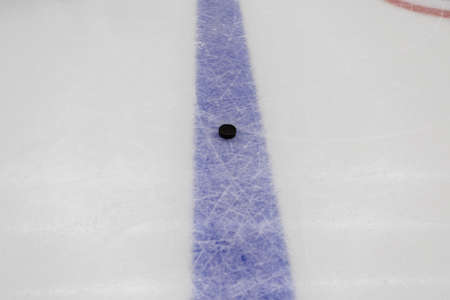 detail blue line with puck on ice hockey rinkの写真素材