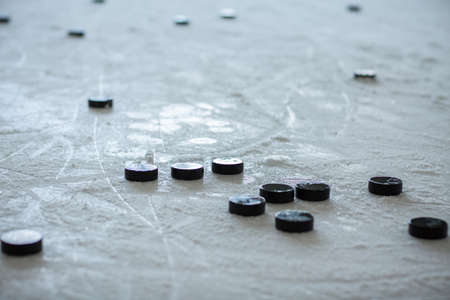 hockey pucks on empty ice rink