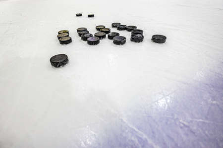 hockey pucks on empty ice rink