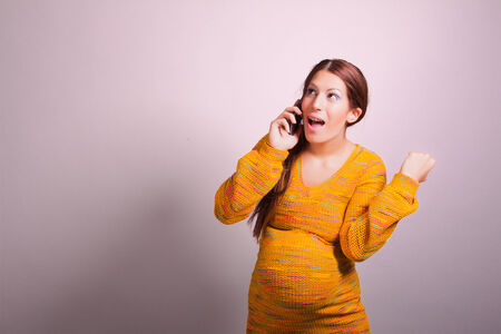 portrait of pregnant woman using cell phoneの写真素材