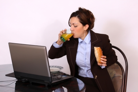 portrait of businesswoman eating by the deskの写真素材