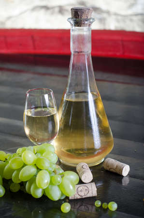 White wine in a glass on a wooden barrel. The concept of wine making.の写真素材