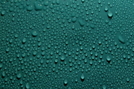 Drops on the green background, photographed on the green plastic background