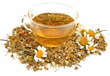 Chamomile leaves with flowers on which sits a cup of chamomileの写真素材
