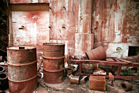 Rusty cans next to each other on red backgroundの写真素材