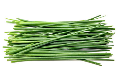 Chive leaves stacked next to each other surrounded by white backgroundの写真素材