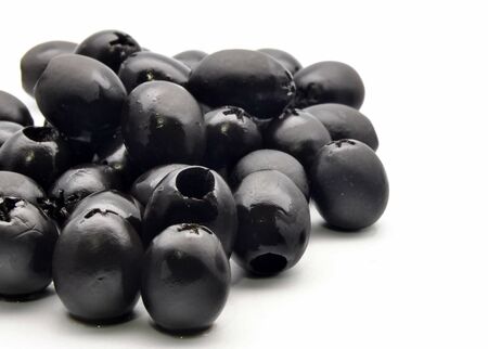 Black olives stacked side by side surrounded by white backgroundの写真素材