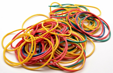 Colored rubber bands next to each other surrounded by white background