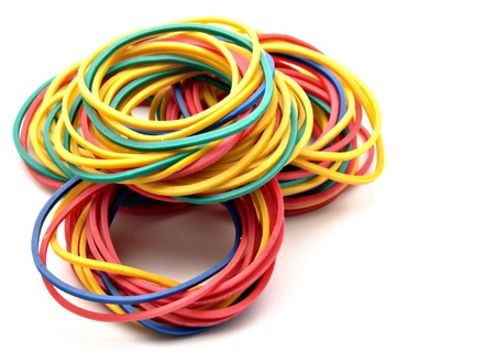 Colored rubber bands next to each other surrounded by white background